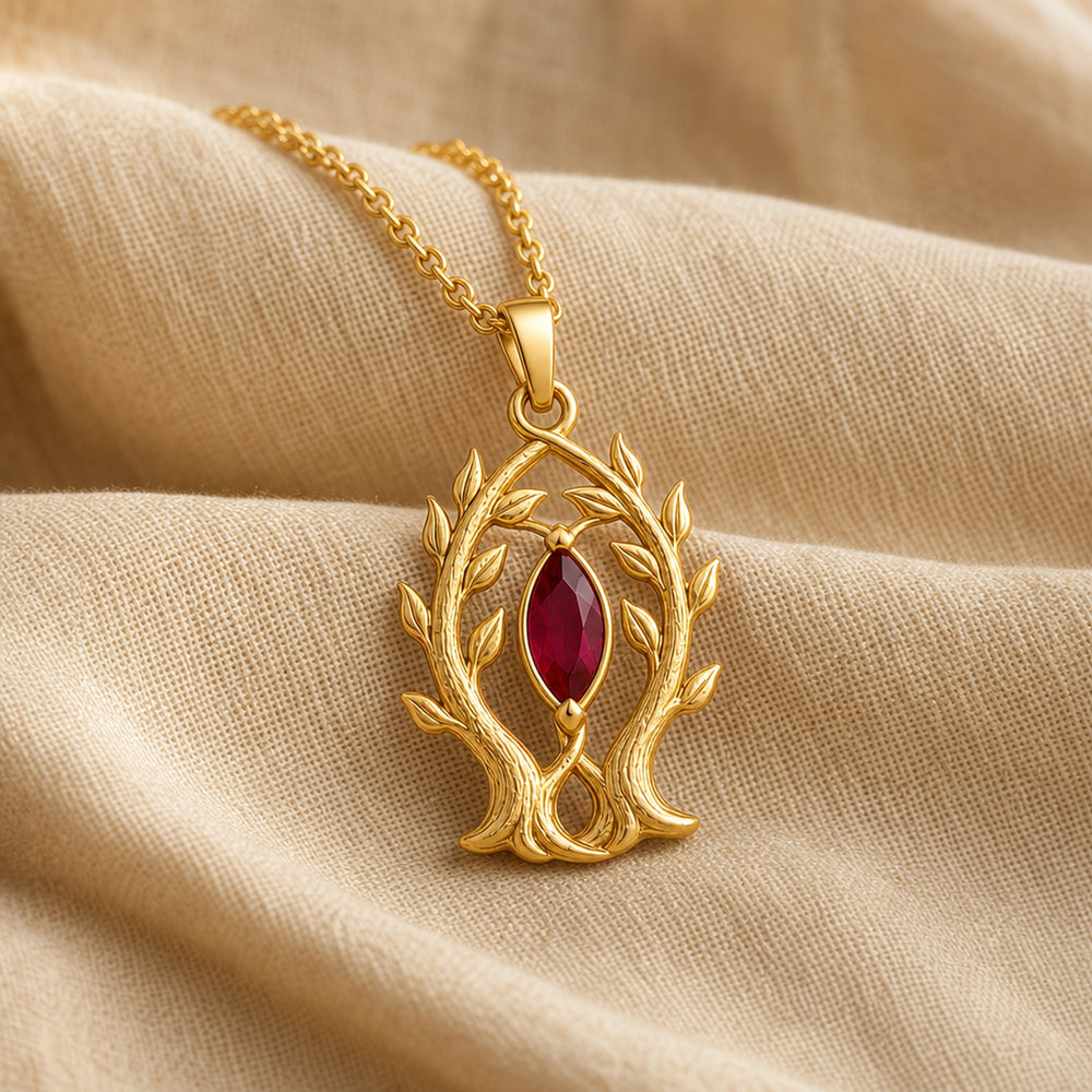Marquise ruby branch pendant in 925 sterling silver, featuring a deep red faceted marquise stone held in a leaf-tipped openwork tree frame. Gold finish.