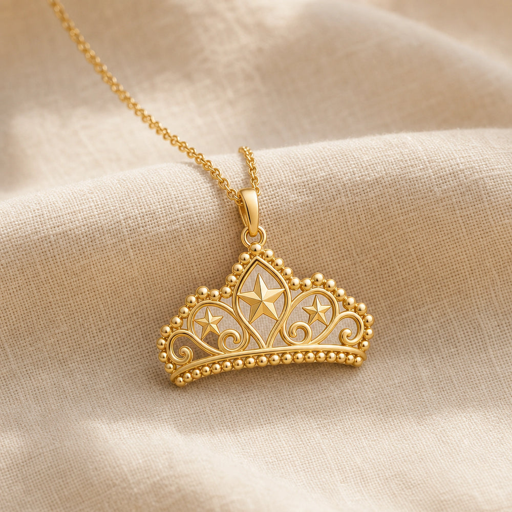 Pearl-bordered star tiara pendant with three raised star motifs, ornate openwork scrollwork, rounded bead edging, and a polished warm yellow-tone finish on a cable chain. Gold finish.