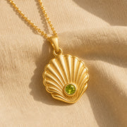 925 sterling silver Pearl Shell pendant with raised fan-shaped fluting and a round green peridot centerpiece. Gold finish.
