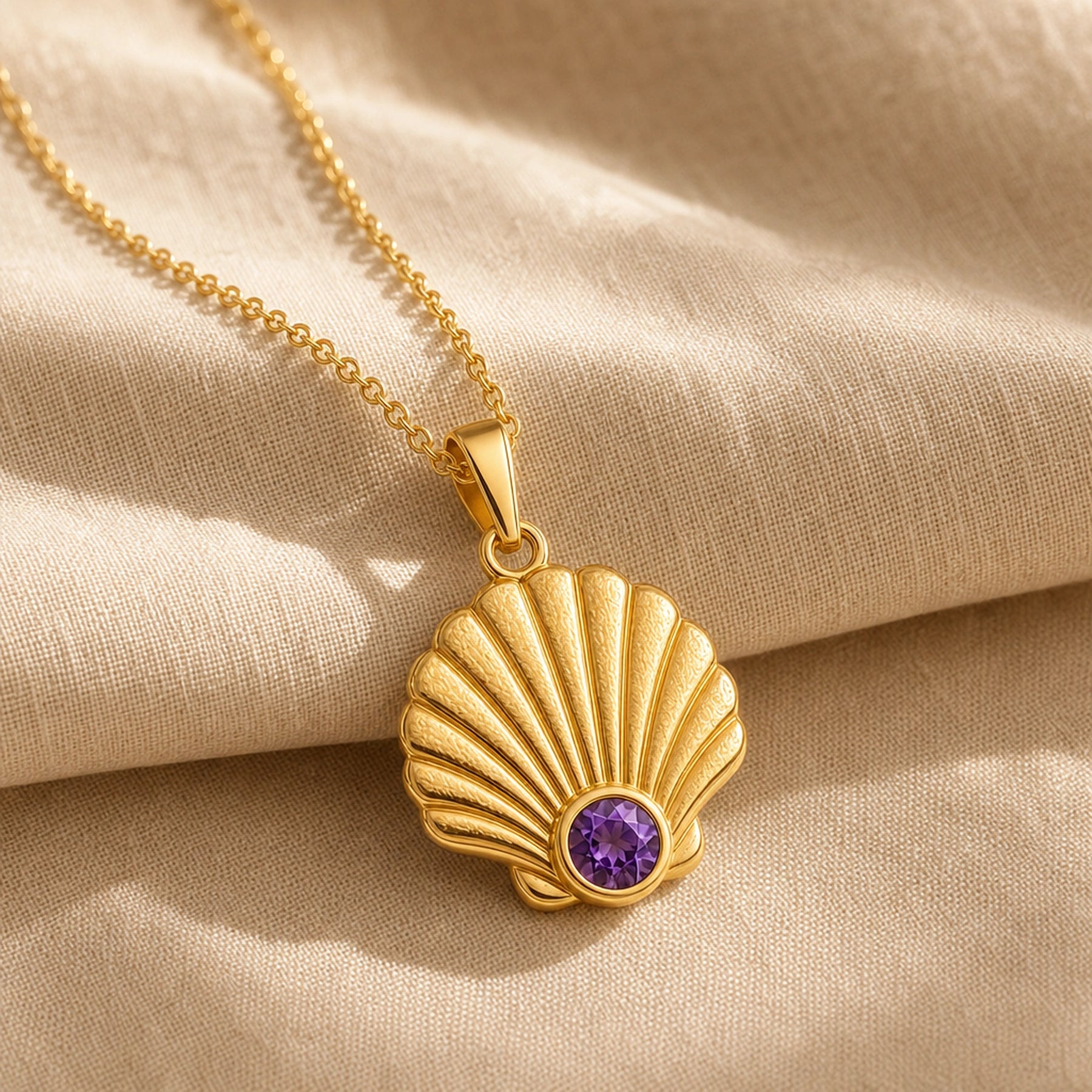 925 sterling silver fan-shaped seashell pendant with fluted relief and a round purple amethyst birthstone. Gold finish.