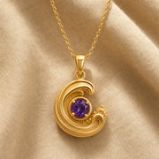 925 sterling silver wavecrest pendant curling around a round purple amethyst centerpiece with flowing textured details. Gold finish.