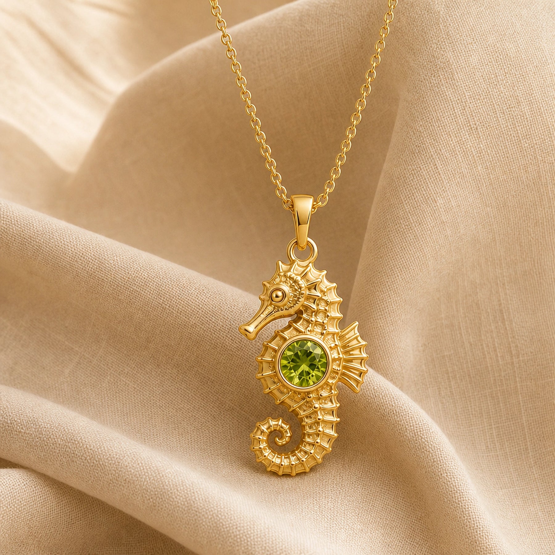 925 sterling silver seahorse pendant with a curled tail, sculpted marine details and a round green peridot centerpiece. Gold finish.