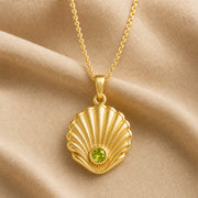 925 sterling silver Pearl Shell pendant with raised fan-shaped fluting and a round green peridot centerpiece. Gold finish.