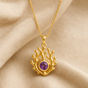 925 sterling silver branching coral pendant embracing a round purple amethyst birthstone centerpiece. Gold finish.