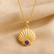925 sterling silver fan-shaped seashell pendant with fluted relief and a round purple amethyst birthstone. Gold finish.