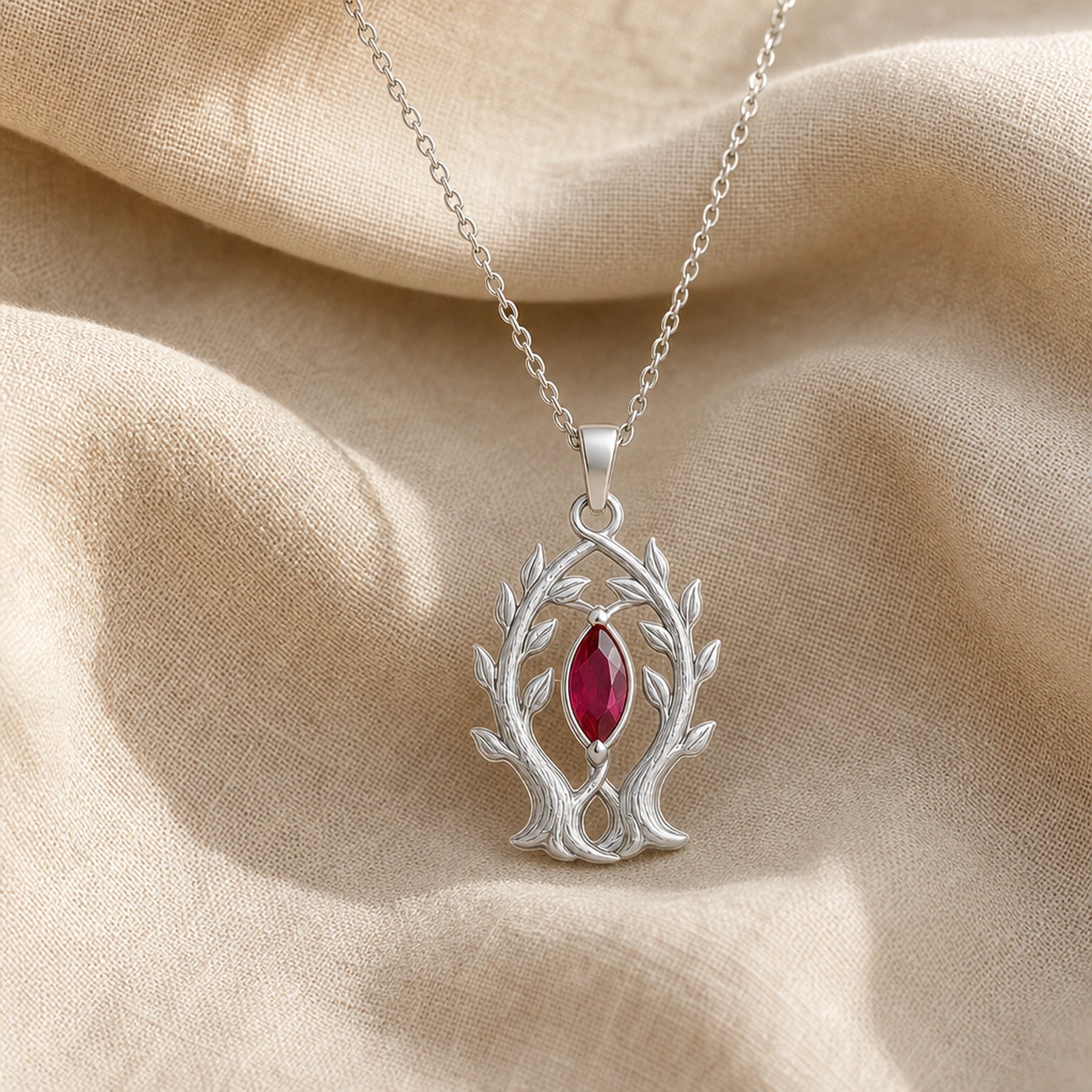 Marquise ruby branch pendant in 925 sterling silver, featuring a deep red faceted marquise stone held in a leaf-tipped openwork tree frame. Silver finish.