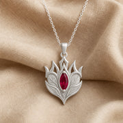 Ruby Elven Crownleaf pendant with layered engraved leaf details, pointed crown-like shapes, and a deep red marquise-shaped stone in a raised central setting. Silver finish.
