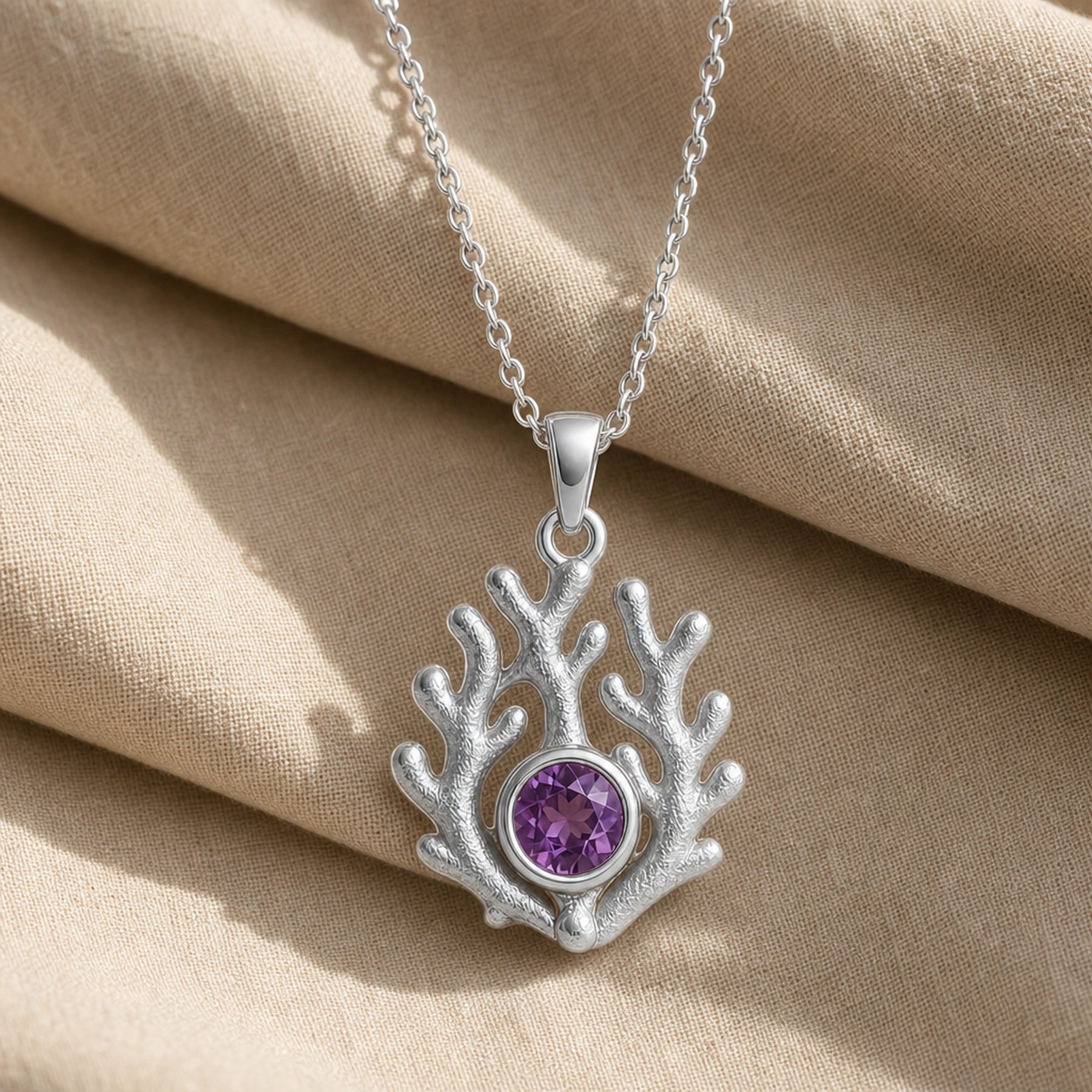 925 sterling silver branching coral pendant embracing a round purple amethyst birthstone centerpiece. Silver finish.