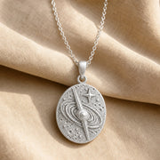 925 sterling silver oval quasar relief pendant with orbital rings, textured celestial details and a raised star. Silver finish.