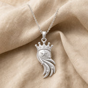 Star-crowned comet pendant with a raised central star, smaller stars along layered sweeping comet trails, and a detailed beaded crown in a warm yellow-toned finish. Silver finish.