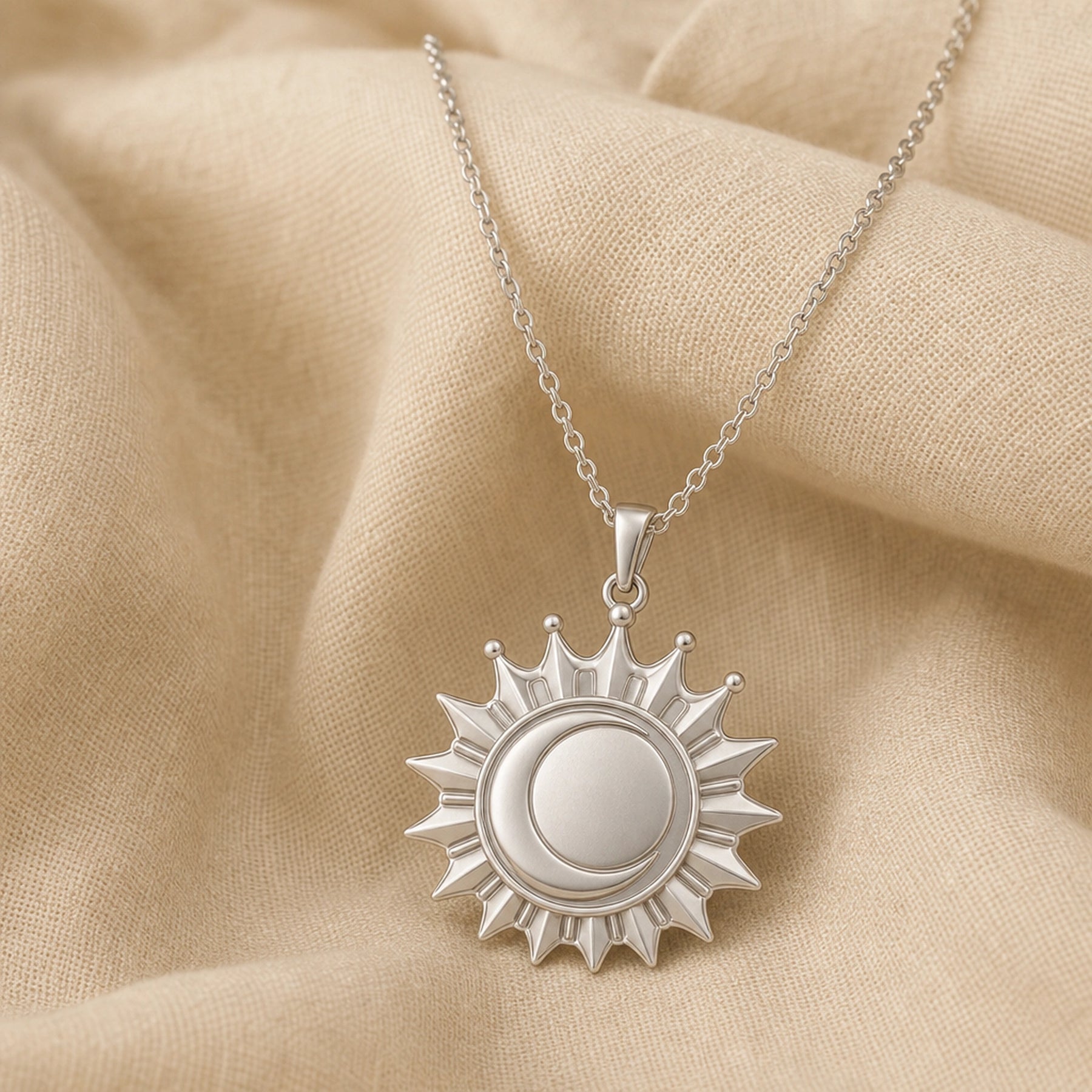 Regal eclipse sunray crown pendant with a raised circular center, pointed radiant rays, crown-like arches, and polished warm yellow finish on a cable chain. Silver finish.