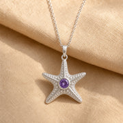 925 sterling silver five-arm starfish pendant with raised bead texture and a round purple amethyst centerpiece. Silver finish.
