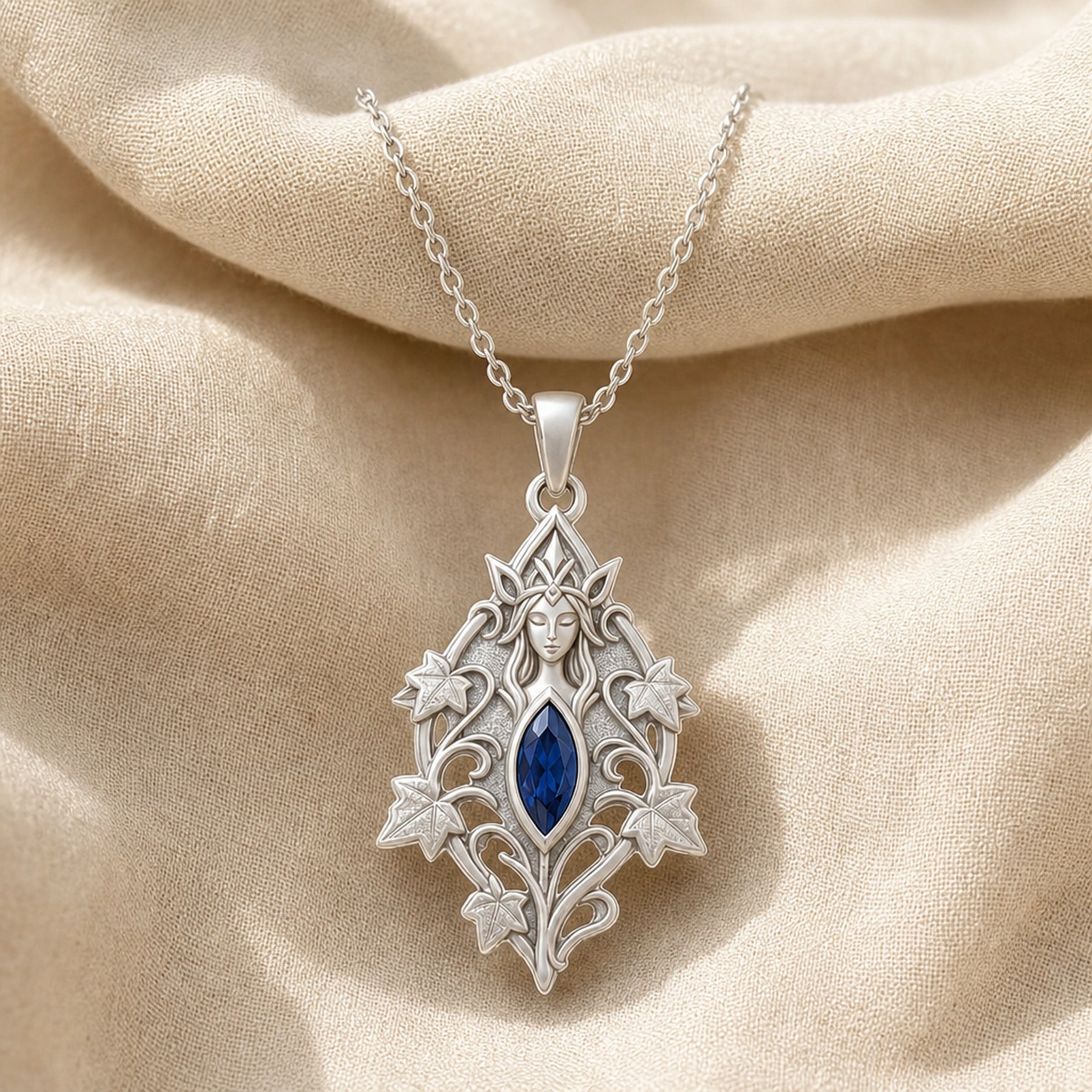 Sapphire ivy elven princess pendant with a deep blue marquise-shaped stone in a framed setting, surrounded by raised ivy leaves, curling vines, and detailed fantasy relief. Silver finish.
