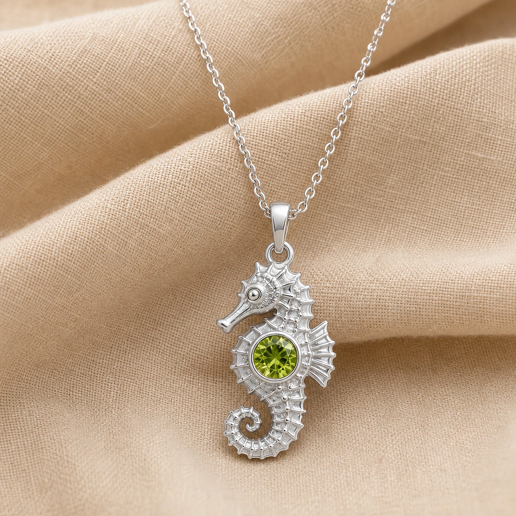 925 sterling silver seahorse pendant with a curled tail, sculpted marine details and a round green peridot centerpiece. Silver finish.