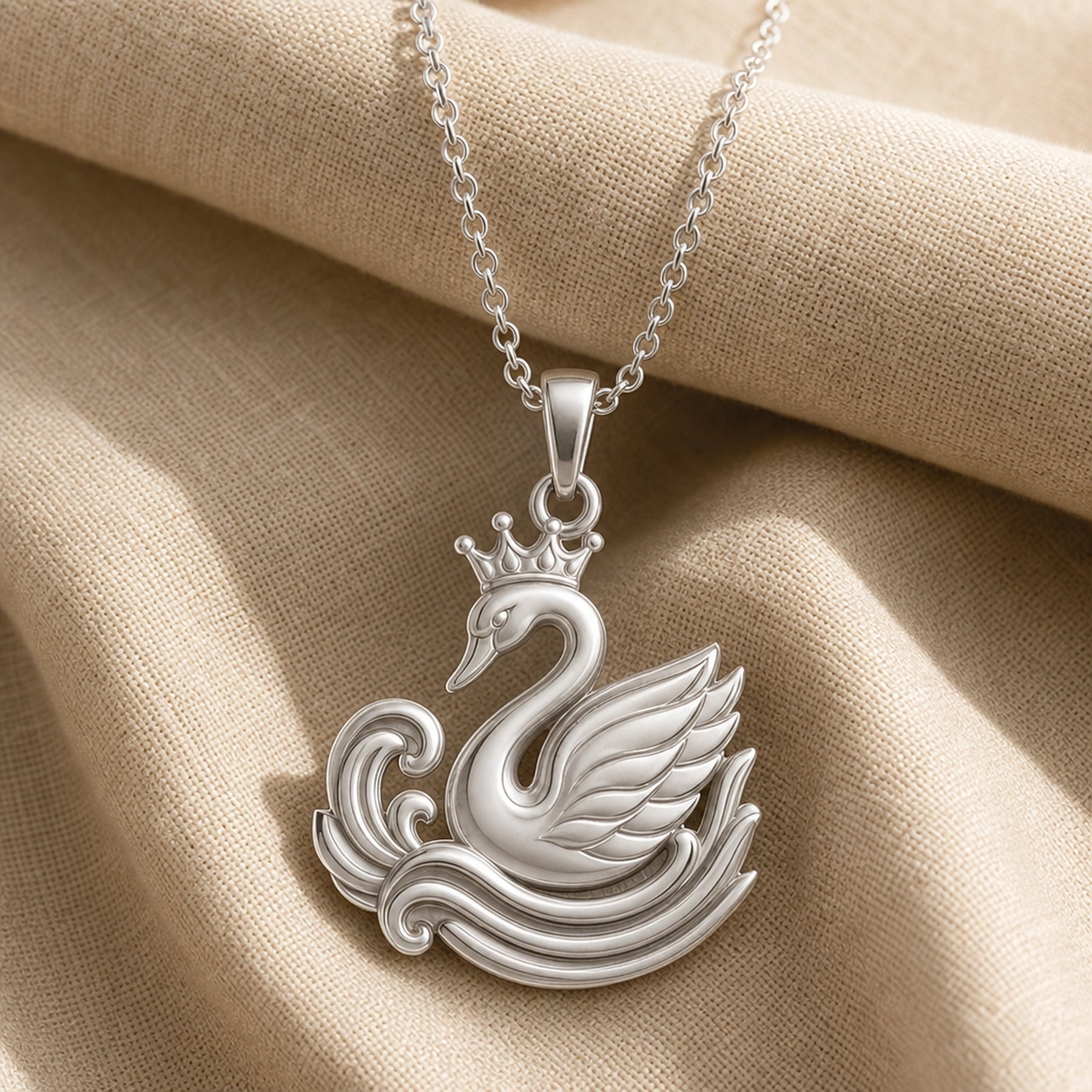 Crowned swan ripple pendant in a warm yellow finish, featuring a raised crown, curved swan neck, layered feather wing, and sculpted wave relief with no gemstone or stone setting. Silver finish.