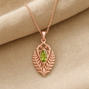 Marquise peridot fern pendant with a vivid green faceted stone in a smooth setting, framed by raised elven fern leaves, openwork scrolls, and botanical relief details. Rose gold finish.