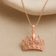 Lily star crown pendant with sculpted flower petals, openwork crown scrolls and raised star details, suspended from a cable chain in 925 sterling silver. Rose gold finish.