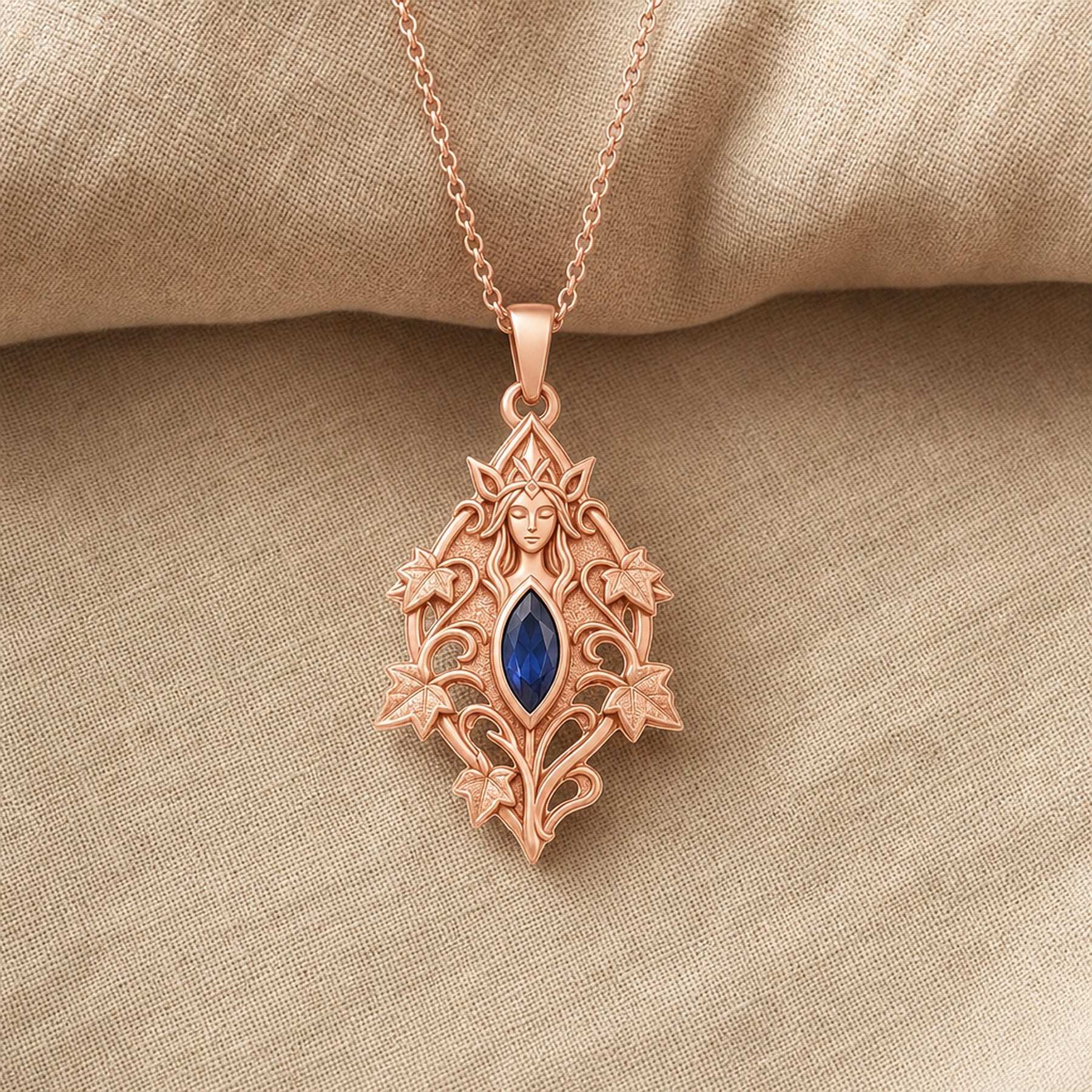 Sapphire ivy elven princess pendant with a deep blue marquise-shaped stone in a framed setting, surrounded by raised ivy leaves, curling vines, and detailed fantasy relief. Rose gold finish.