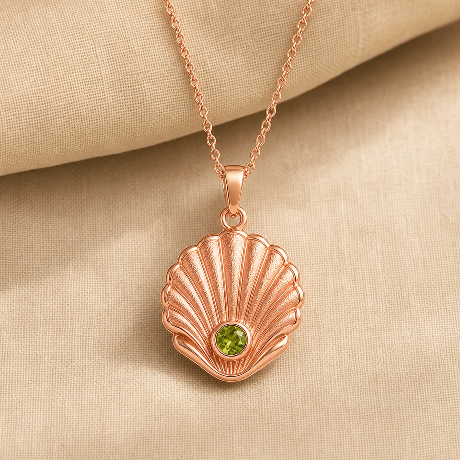 925 sterling silver Pearl Shell pendant with raised fan-shaped fluting and a round green peridot centerpiece. Rose gold finish.