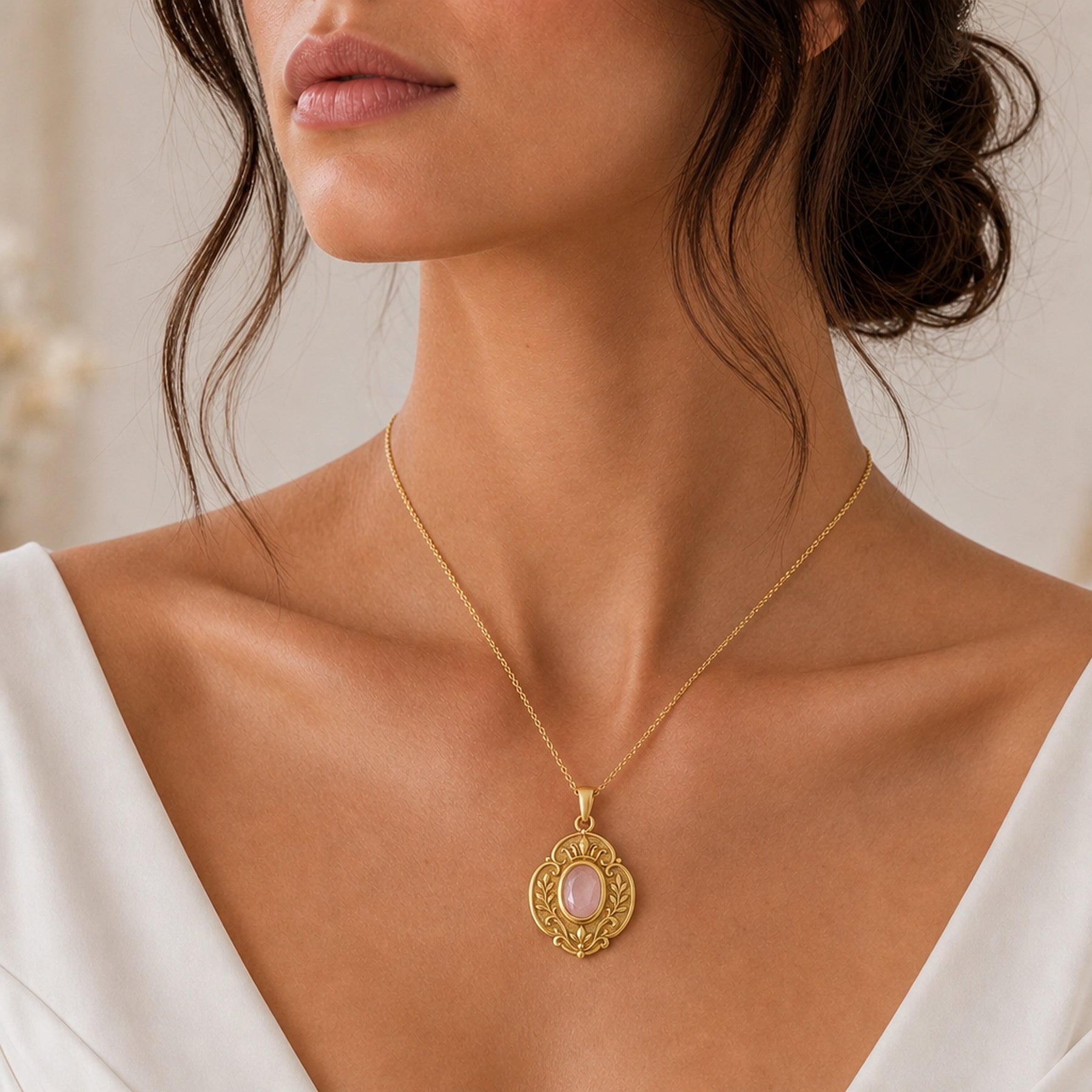 Rose quartz regal garden pendant with a faceted oval pink stone in a smooth bezel setting, surrounded by raised leaf motifs, scrollwork, and textured floral details. Worn on a model, front view.