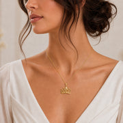 Lily star crown pendant with sculpted flower petals, openwork crown scrolls and raised star details, suspended from a cable chain in 925 sterling silver. Worn on a model, front view.