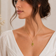 Blue Topaz Laurel Pendant with a green-toned faceted marquise stone, framed by detailed openwork laurel leaves in an elongated elven-inspired 925 sterling silver design. Worn on a model, front view.