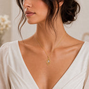 Moonlight crystal elven pendant with a clear marquise-cut crystal in a pointed setting, surrounded by flowing leaf-like openwork and an elegant teardrop-shaped frame. Worn on a model, front view.