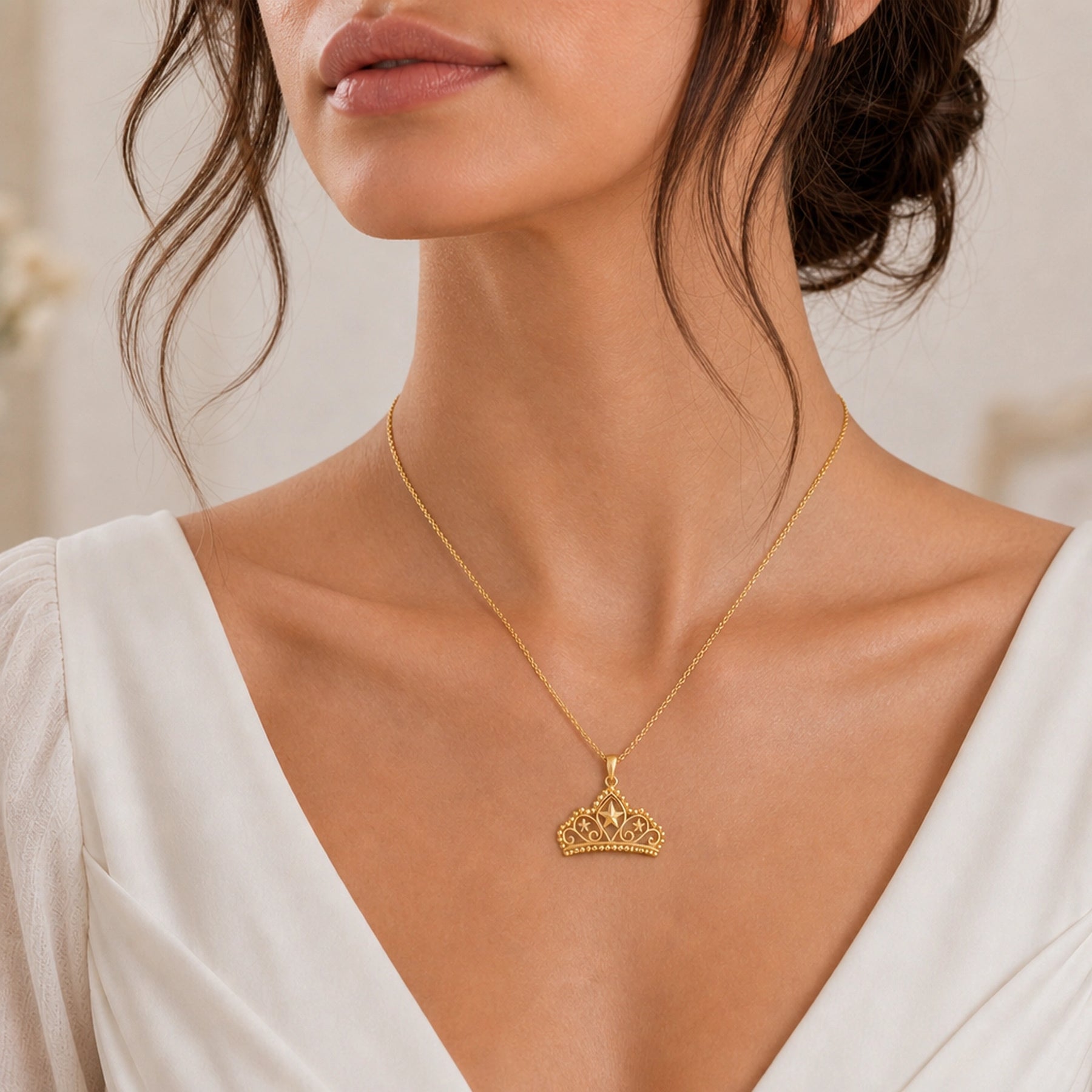 Pearl-bordered star tiara pendant with three raised star motifs, ornate openwork scrollwork, rounded bead edging, and a polished warm yellow-tone finish on a cable chain. Worn on a model, front view.