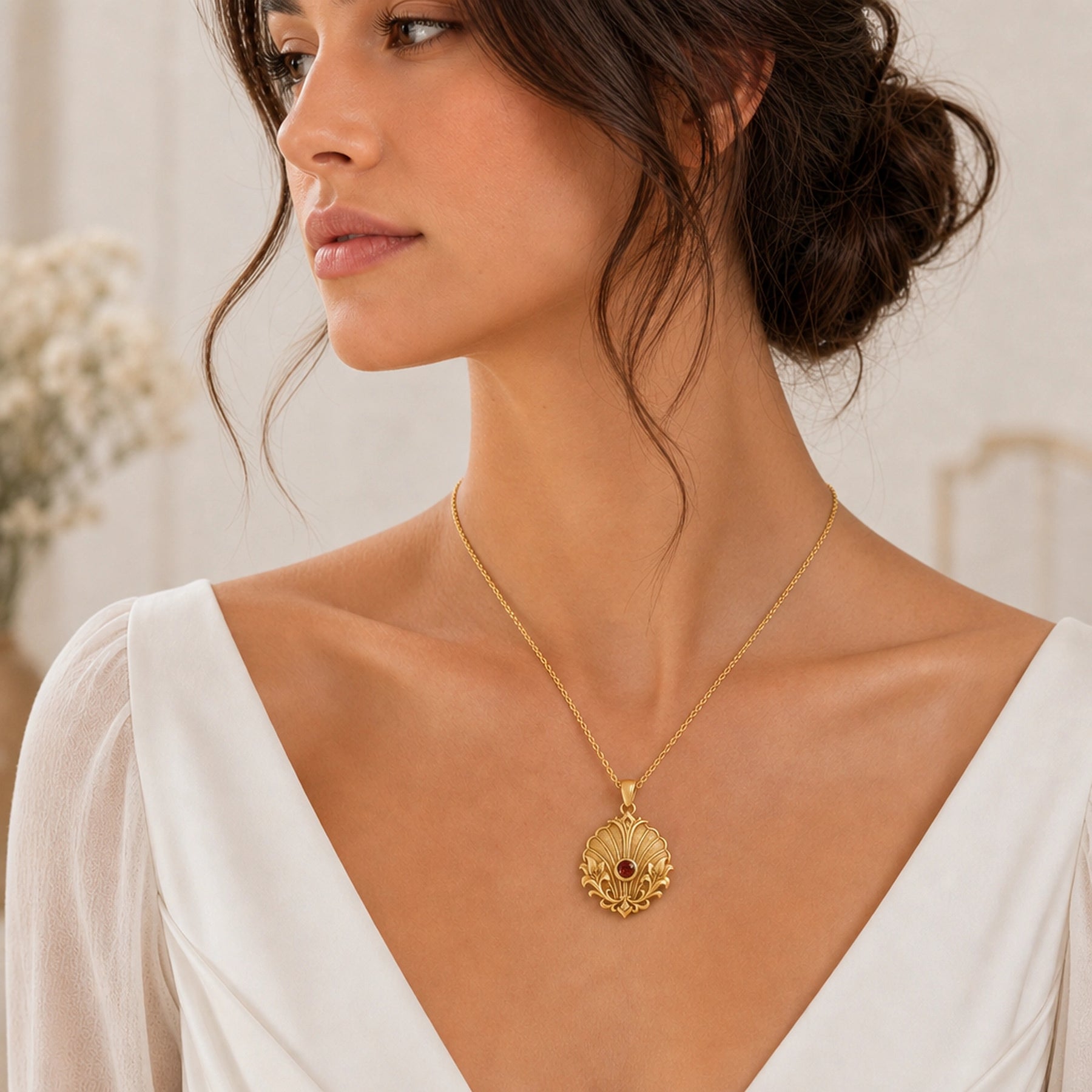 Imperial garnet lily shell pendant with a round deep-red stone in a smooth bezel, framed by raised lily flourishes and textured shell-like fan relief. Worn on a model, angled view.