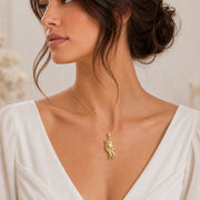 Star-crowned comet pendant with a raised central star, smaller stars along layered sweeping comet trails, and a detailed beaded crown in a warm yellow-toned finish. Worn on a model, angled view.