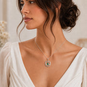 Emerald Elven Moonleaf pendant in 925 sterling silver, featuring a faceted marquise green stone set within an open crescent of sculpted leaves and a small star detail. Worn on a model, angled view.