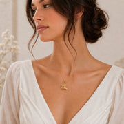 Lily star crown pendant with sculpted flower petals, openwork crown scrolls and raised star details, suspended from a cable chain in 925 sterling silver. Worn on a model, angled view.