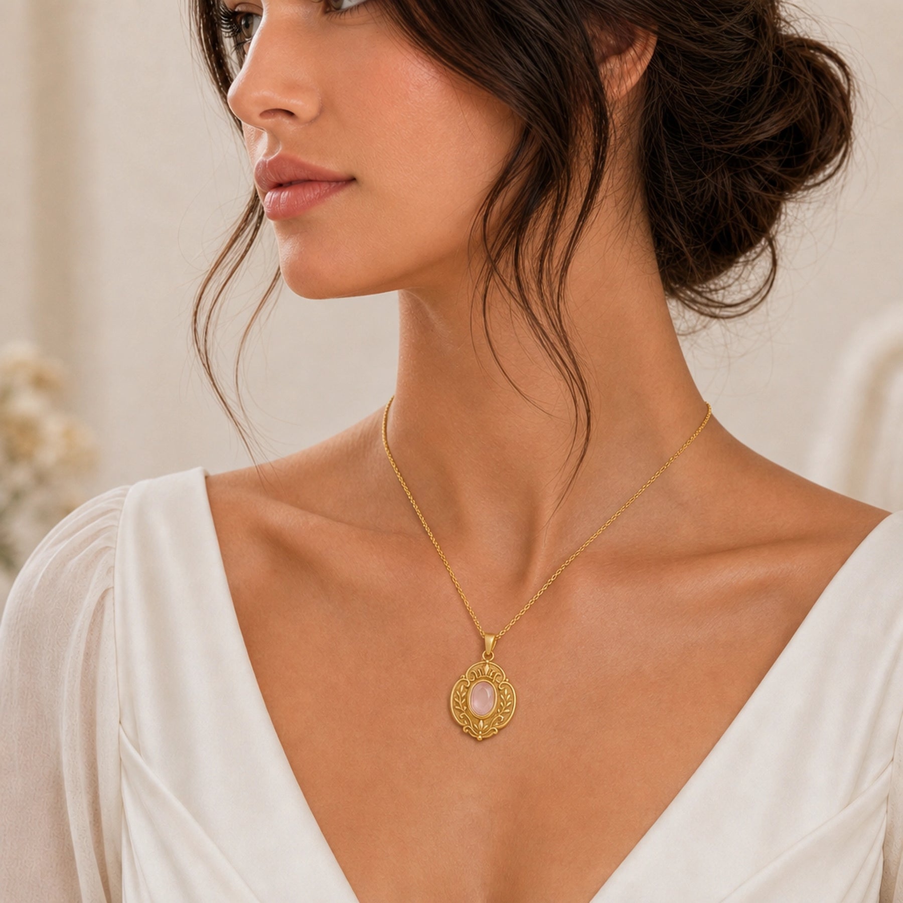 Rose quartz regal garden pendant with a faceted oval pink stone in a smooth bezel setting, surrounded by raised leaf motifs, scrollwork, and textured floral details. Worn on a model, angled view.