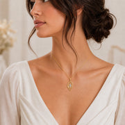 Moonlight crystal elven pendant with a clear marquise-cut crystal in a pointed setting, surrounded by flowing leaf-like openwork and an elegant teardrop-shaped frame. Worn on a model, angled view.
