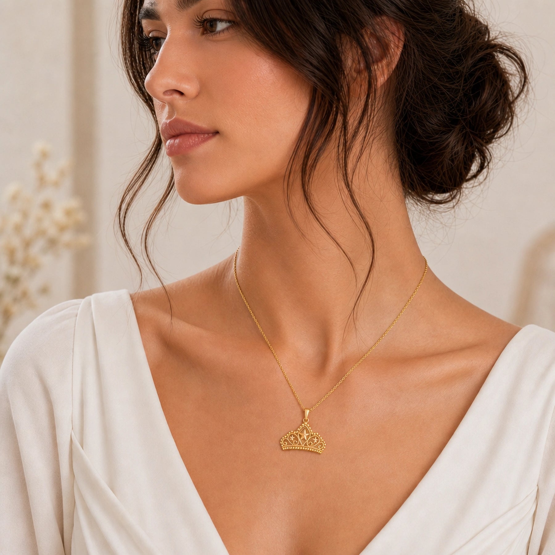 Pearl-bordered star tiara pendant with three raised star motifs, ornate openwork scrollwork, rounded bead edging, and a polished warm yellow-tone finish on a cable chain. Worn on a model, angled view.